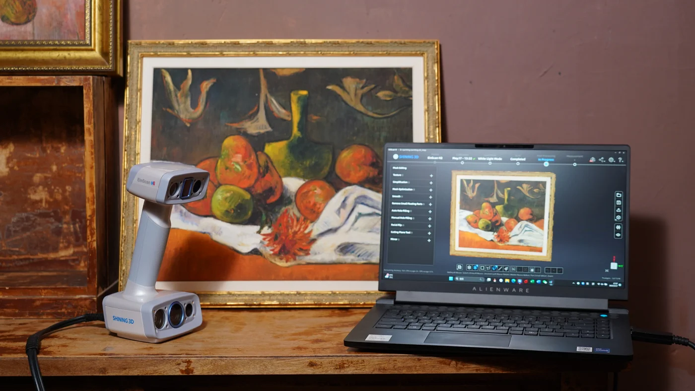 EinScan H2 ao lado de uma pintura e de sua digitalização no computador